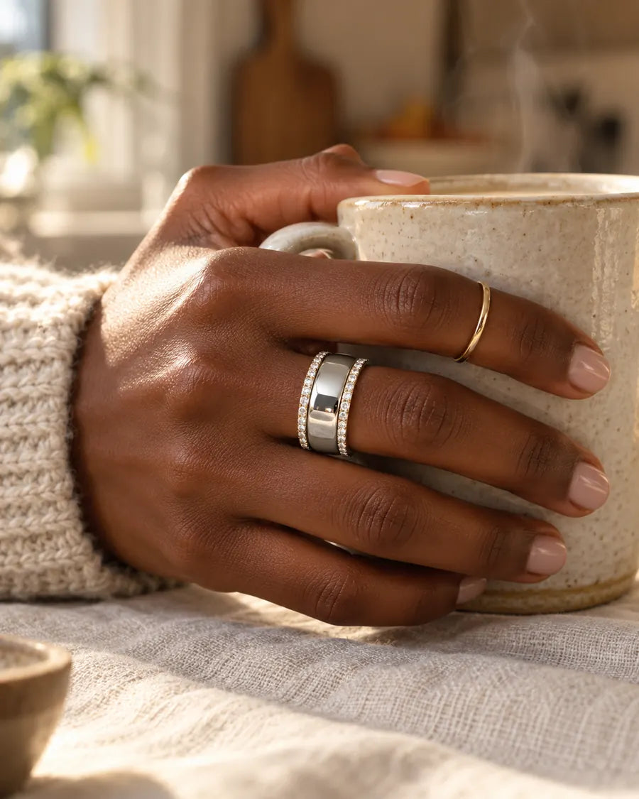 HALO Round in 14k white gold with round diamonds, worn over a silver Oura Ring while holding a ceramic coffee mug
