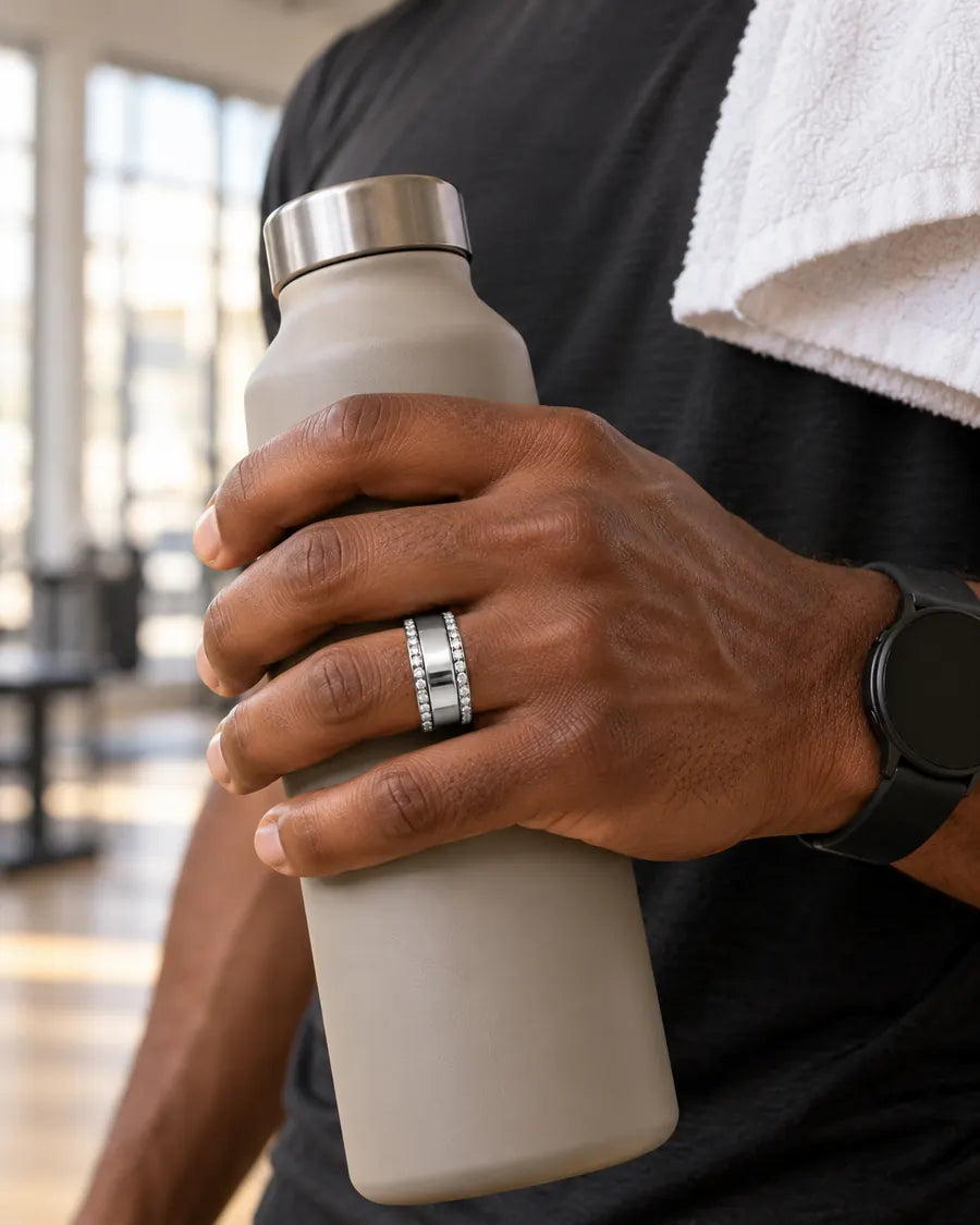 Man wearing HALO Round in 14k white gold over a silver Oura Ring, holding a water bottle after a workout