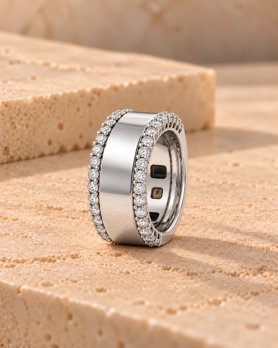 HALO Round in 14k white gold with two rows of round brilliant diamonds, worn over a silver Oura Ring, standing on sandstone