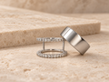 HALO Round in 14k white gold beside a silver Oura Ring on travertine