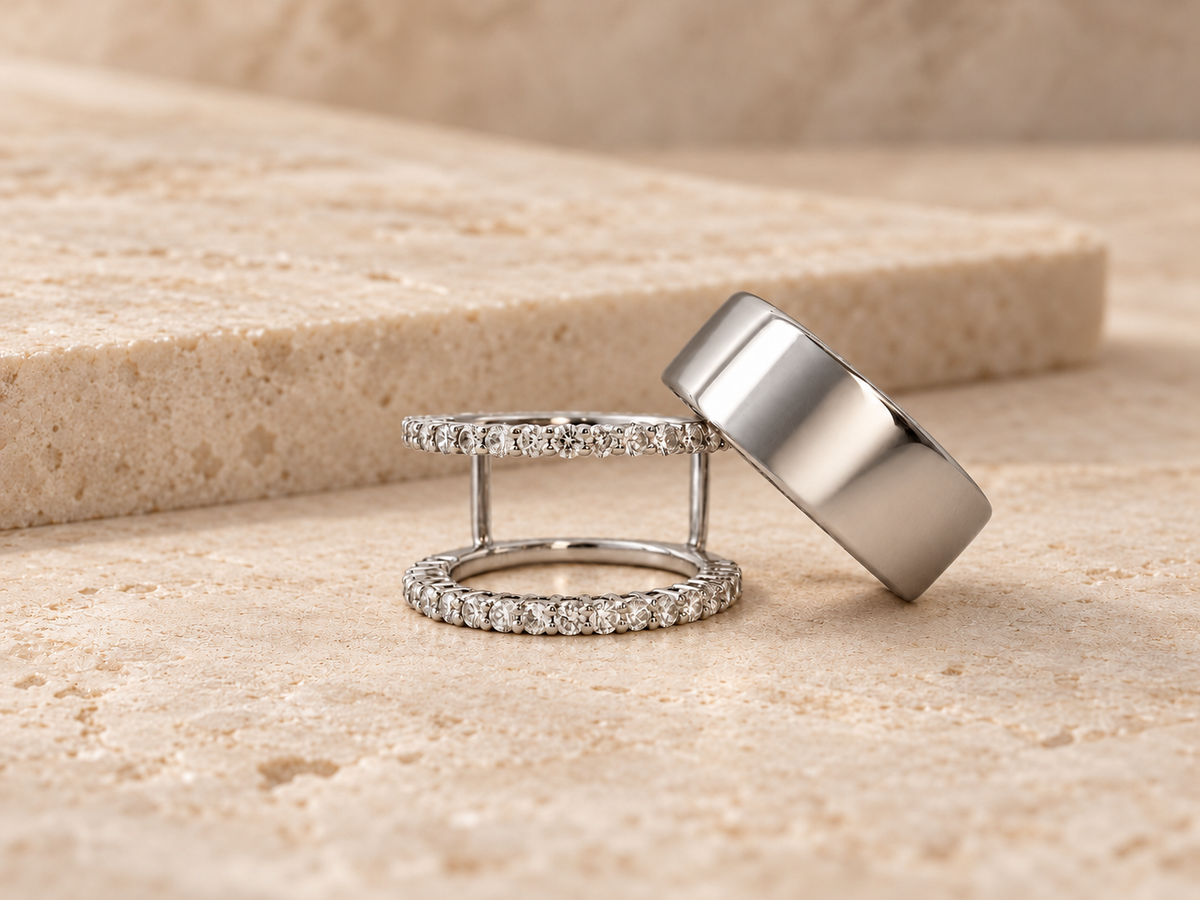 HALO Round in 14k white gold beside a silver Oura Ring on travertine