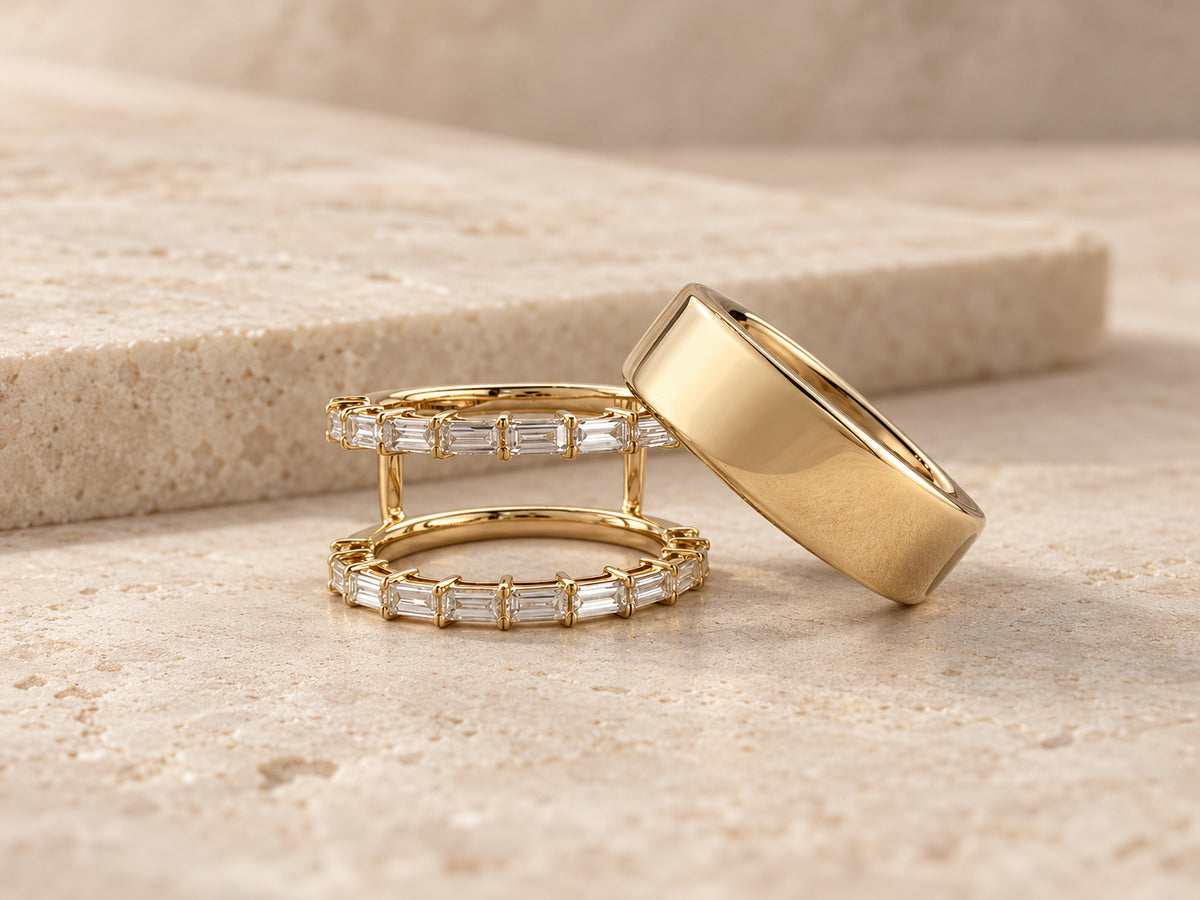 HALO Baguette in 14k yellow gold beside a gold Oura Ring on travertine
