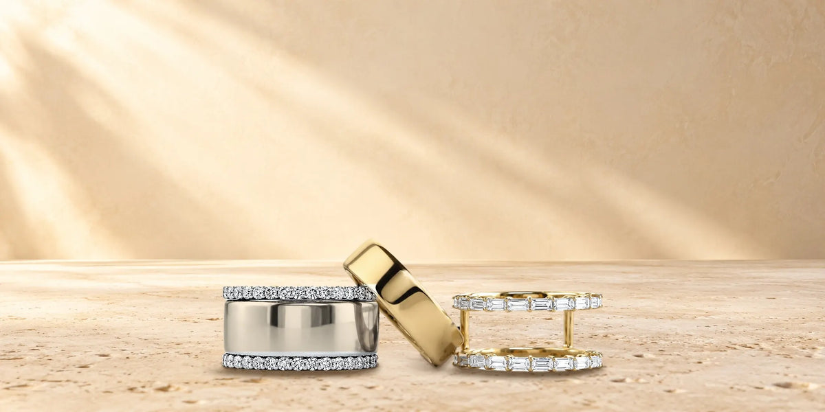 HALO Round in white gold, a gold Oura Ring and HALO Baguette in yellow gold on travertine